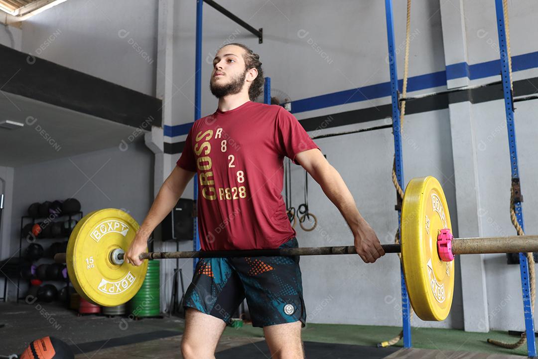 Homem jovem sobre uma academia fazendo musculações Conceito saude melhor
