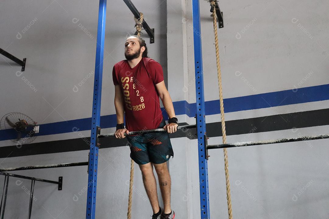 Homem jovem sobre uma academia fazendo musculações Conceito saude melhordw