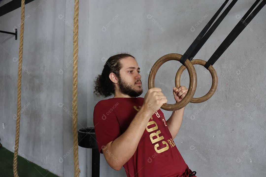 Homem jovem sobre uma academia fazendo musculações Conceito saude melhor
