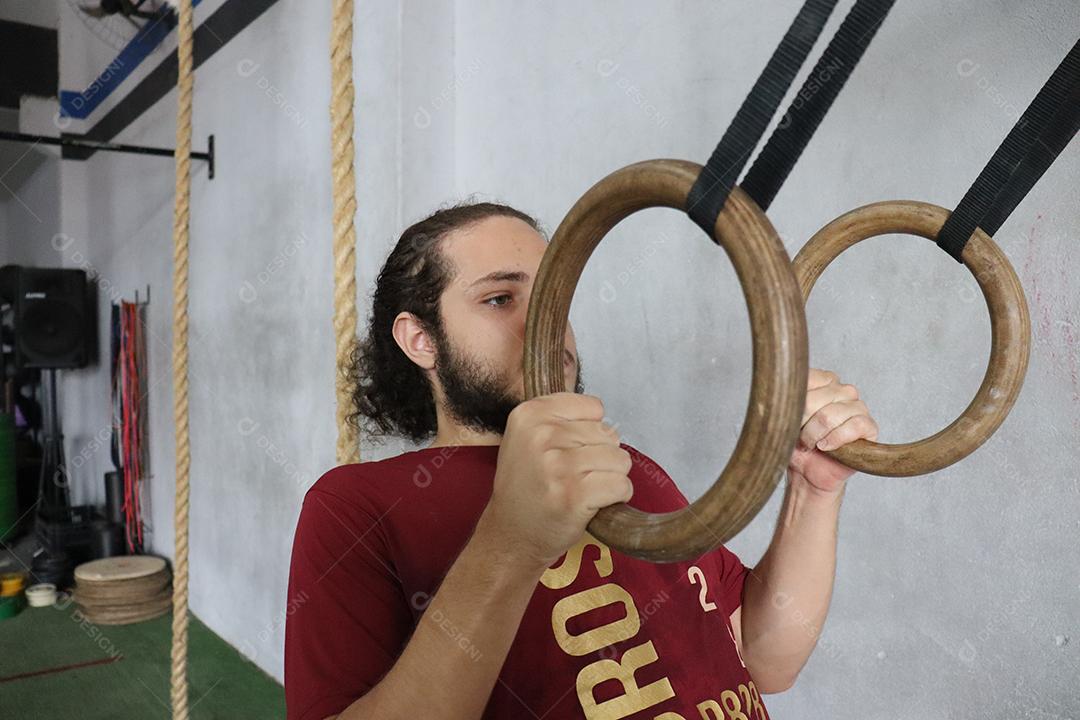 Homem jovem sobre uma academia fazendo musculações Conceito saude melhor