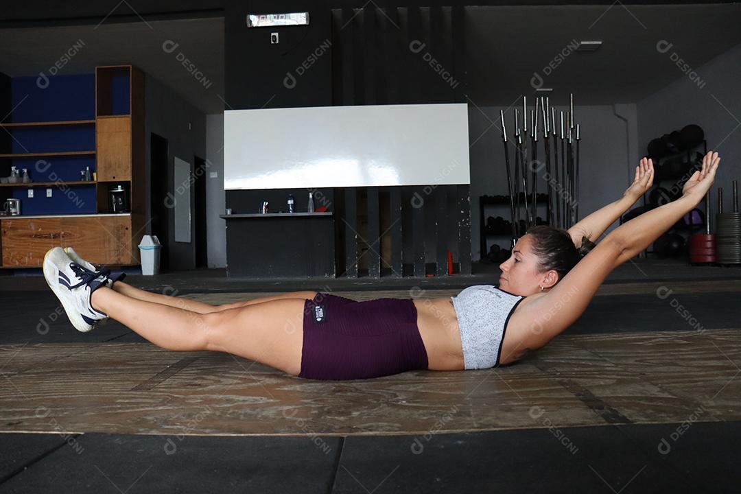 Mulher jovem sobre uma academia fazendo musculações Conceito saude melhor