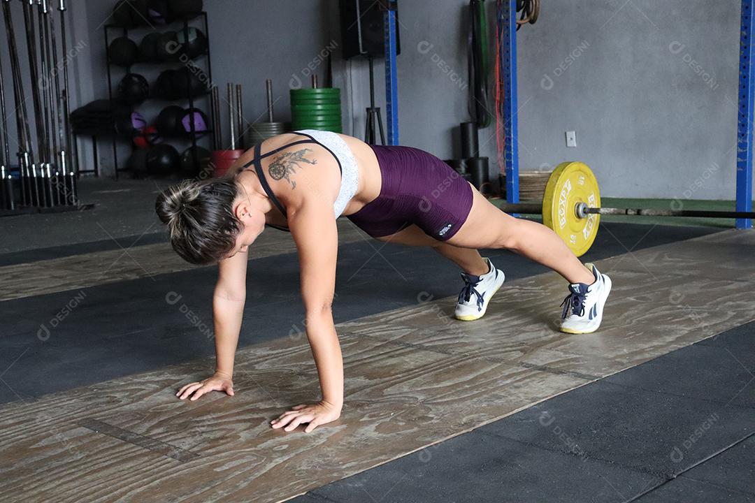 Mulher jovem sobre uma academia fazendo musculações Conceito saude melhor