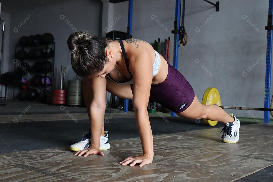 Mulher jovem sobre uma academia fazendo musculações Conceito saude melhor