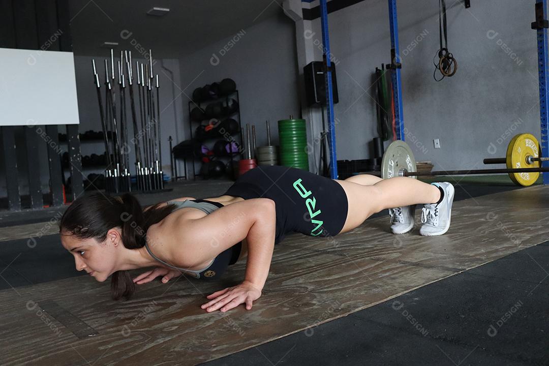 Mulher jovem sobre uma academia fazendo musculações Conceito saude melhor