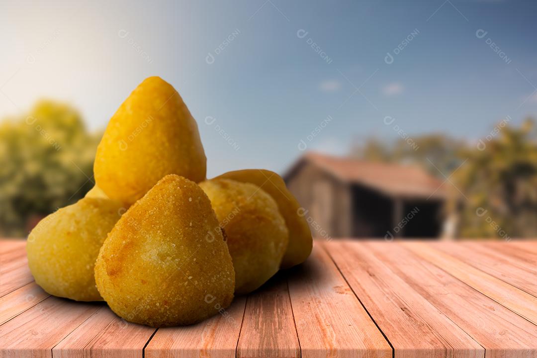 coxinhas e salgadinhos fritos de festa em mesa de madeira com fu