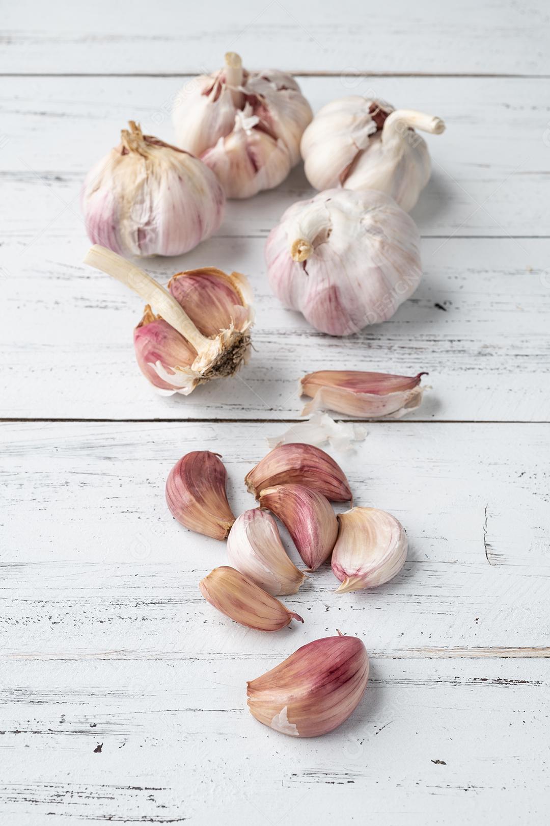 Bulbo de alho e cravo sobre a mesa de madeira.