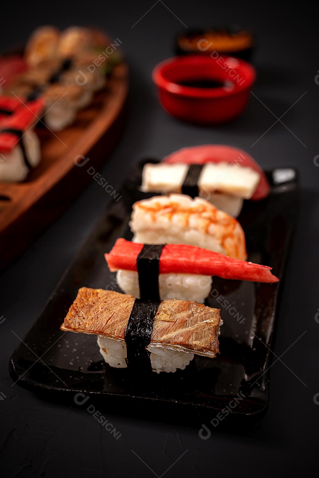 Comida japonesa. Sushi Kome. Salmão, sushi em alga, arroz enroladinho, temperos