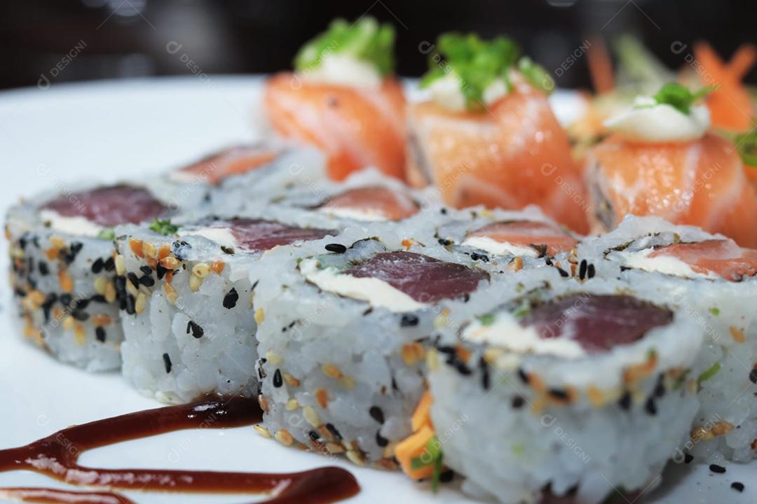 Sushi, cozinha tradicional japonesa. Vários deliciosos sushis no prato decorado, fundo preto