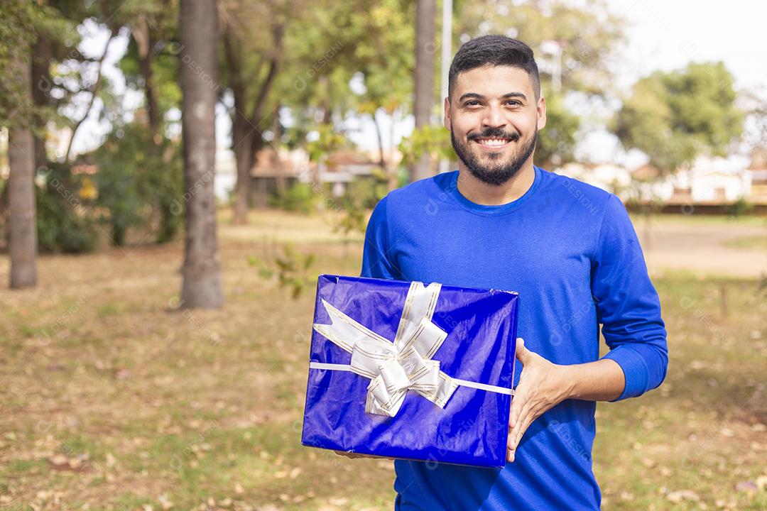 Menino segurando um presente no parque
