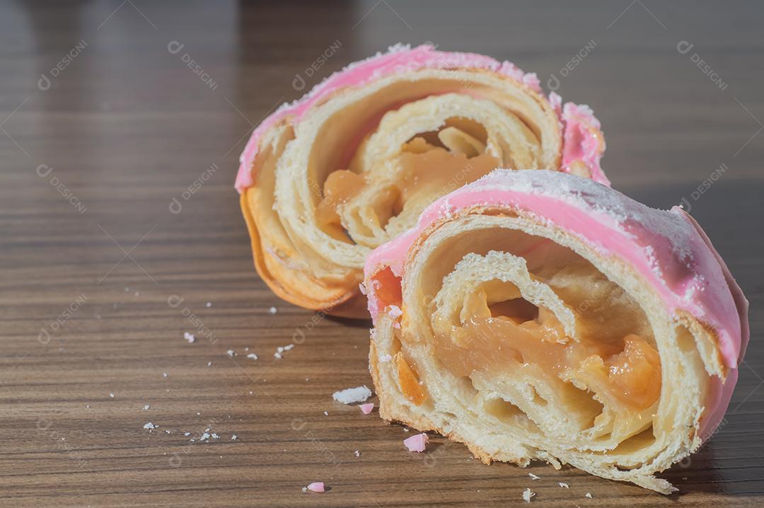 Croissant com cobertura de morango e recheio de doce de leite.