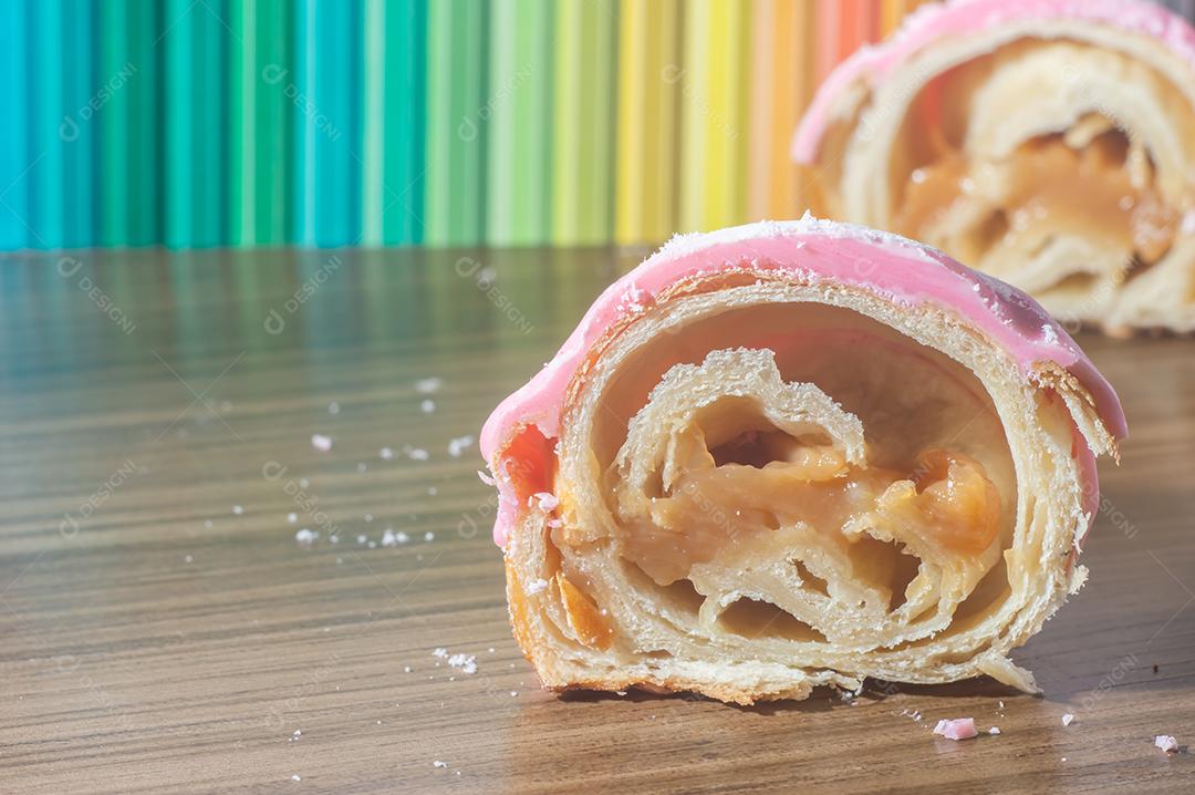 Croissant com cobertura de morango e recheio de doce de leite.