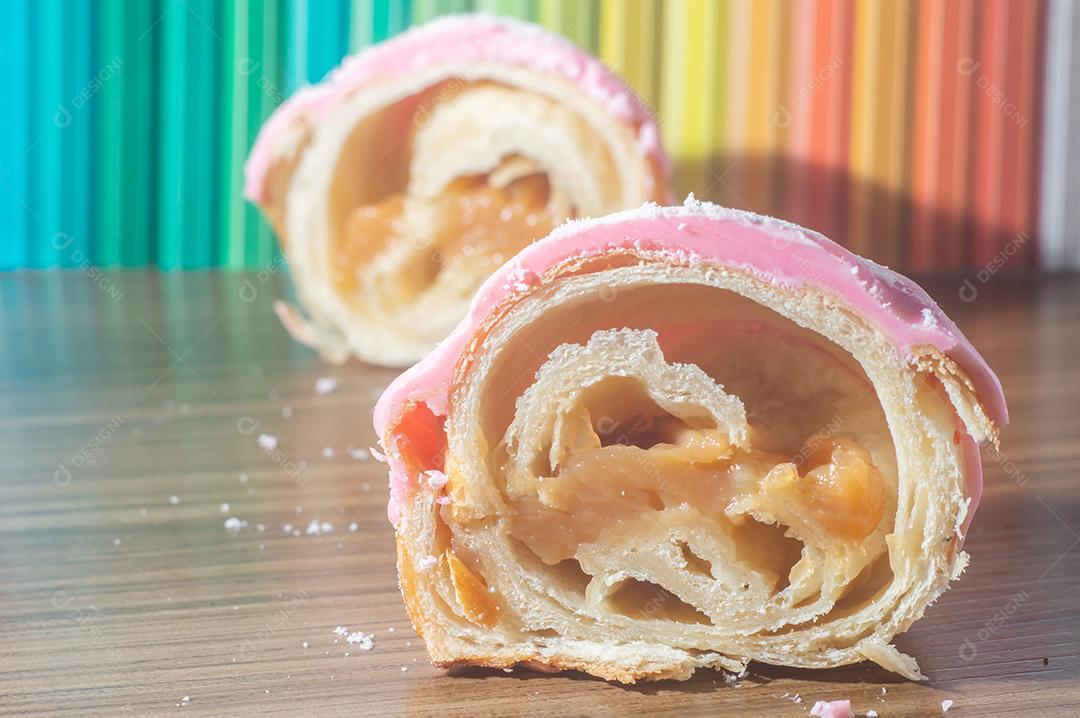 Croissant com cobertura de morango e recheio de doce de leite.