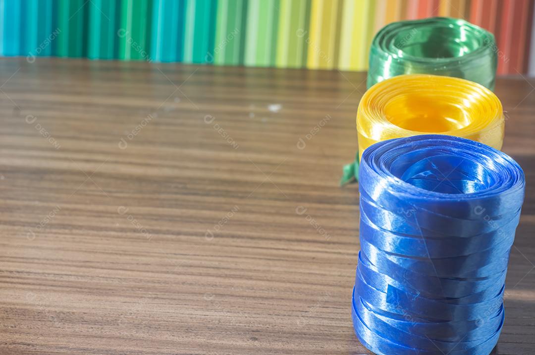 Fitas coloridas com cores amarelo e azul verde com fundo colorido, conceito de cores da bandeira do brasil em uma mesa de madeira.