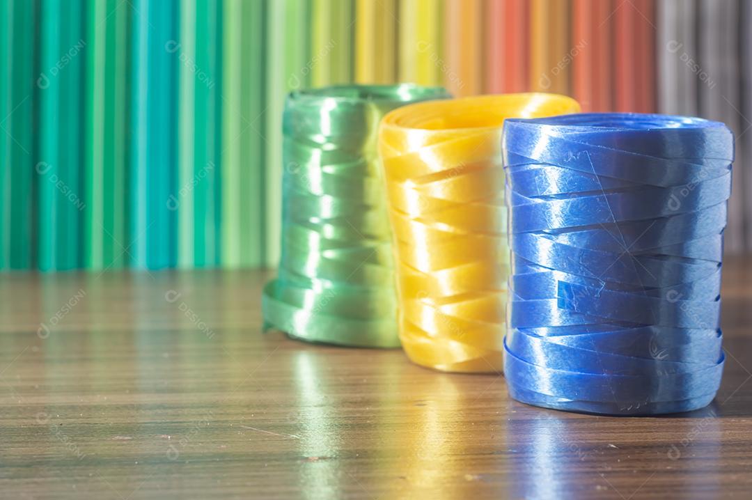 Fitas coloridas com cores amarelo e azul verde com fundo colorido, conceito de cores da bandeira do brasil em uma mesa de madeira.