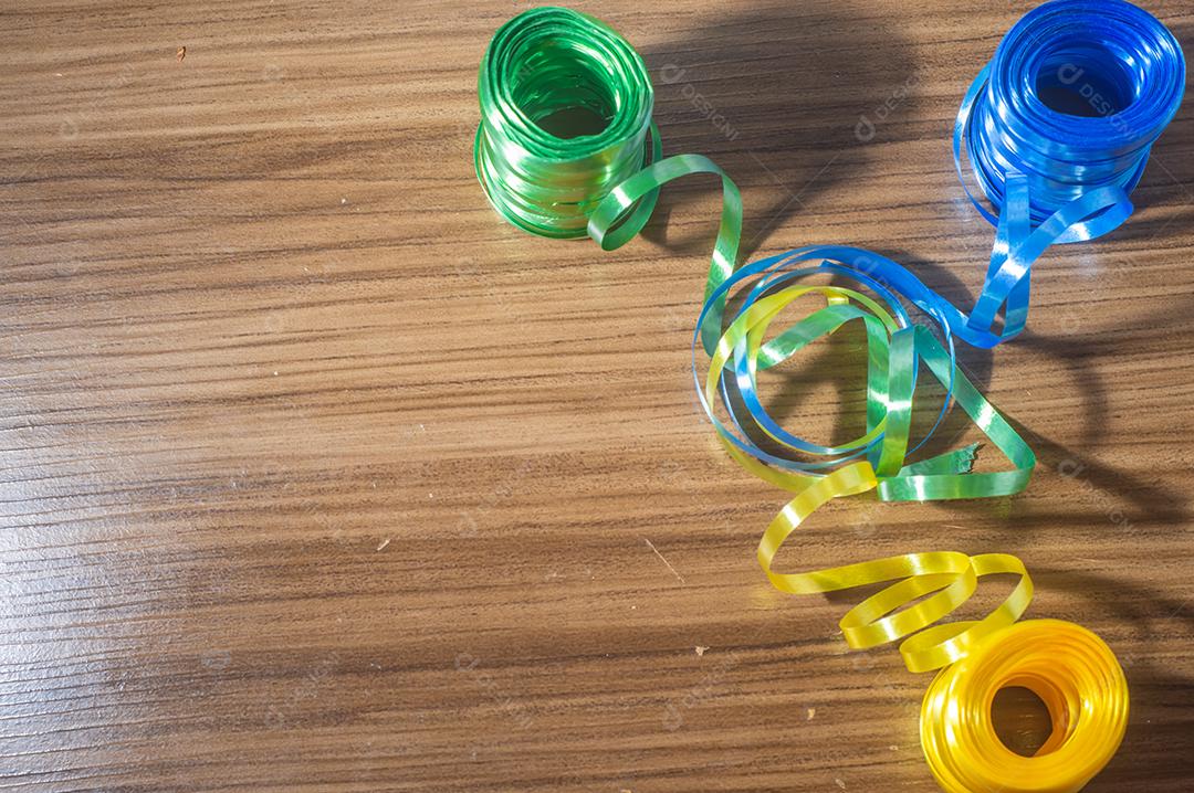 Fitas coloridas com cores amarelo e azul verde com fundo colorido, conceito de cores da bandeira do brasil em uma mesa de madeira.