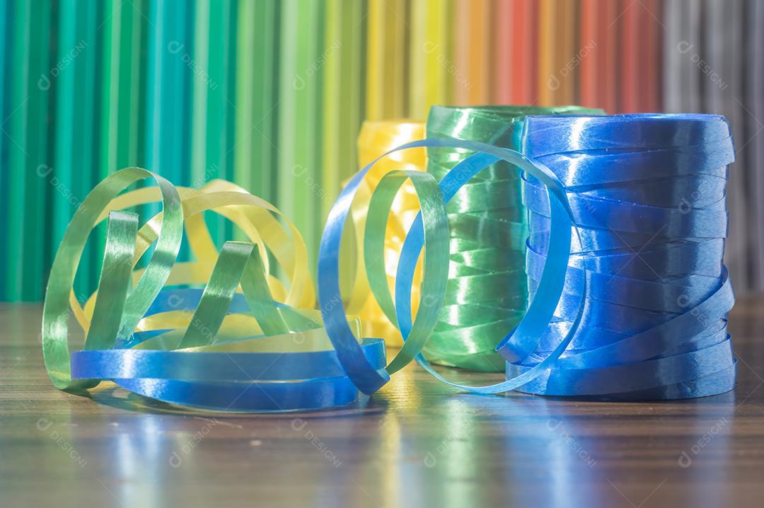 Fitas coloridas com cores amarelo e azul verde com fundo colorido, conceito de cores da bandeira do brasil em uma mesa de madeira.