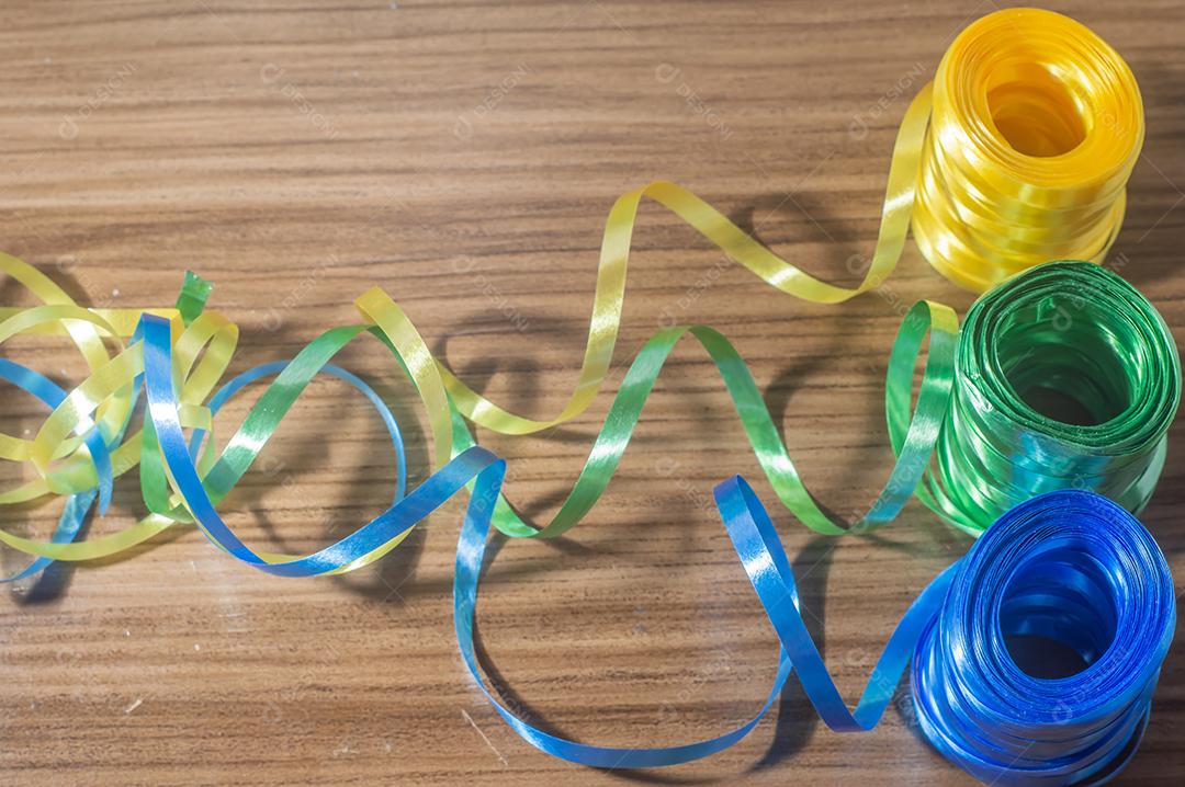 Fitas coloridas com cores amarelo e azul verde com fundo colorido, conceito de cores da bandeira do brasil em uma mesa de madeira.