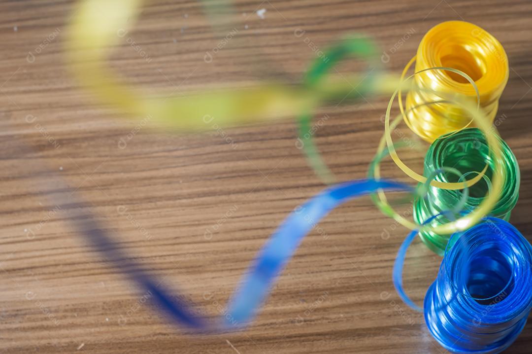 Fitas coloridas com cores amarelo e azul verde com fundo colorido, conceito de cores da bandeira do brasil em uma mesa de madeira.