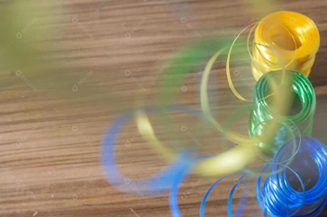 Fitas coloridas com cores amarelo e azul verde com fundo colorido, conceito de cores da bandeira do brasil em uma mesa de madeira.