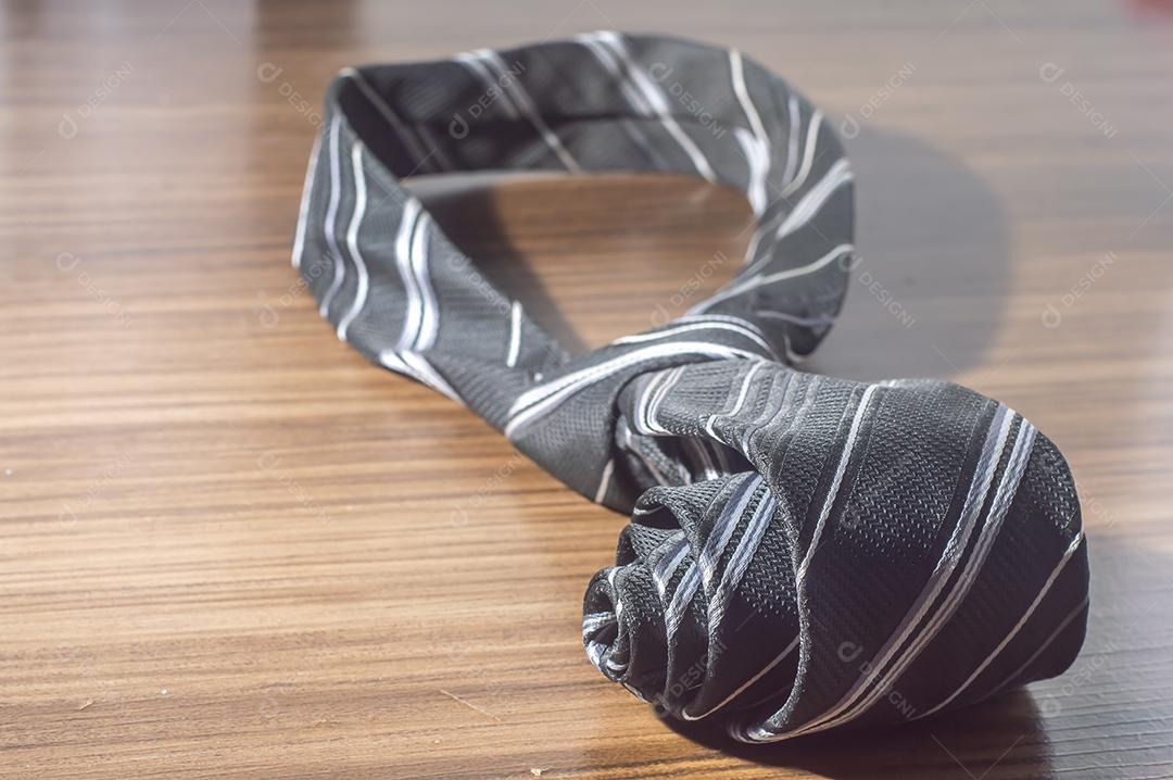 Gravata preta em uma mesa de madeira com espaço de cópia, conceito de dia dos pais.