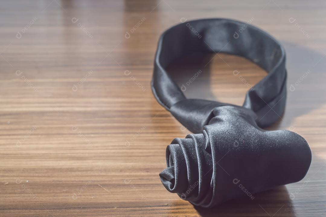 Gravata preta em uma mesa de madeira com espaço de cópia, conceito de dia dos pais.