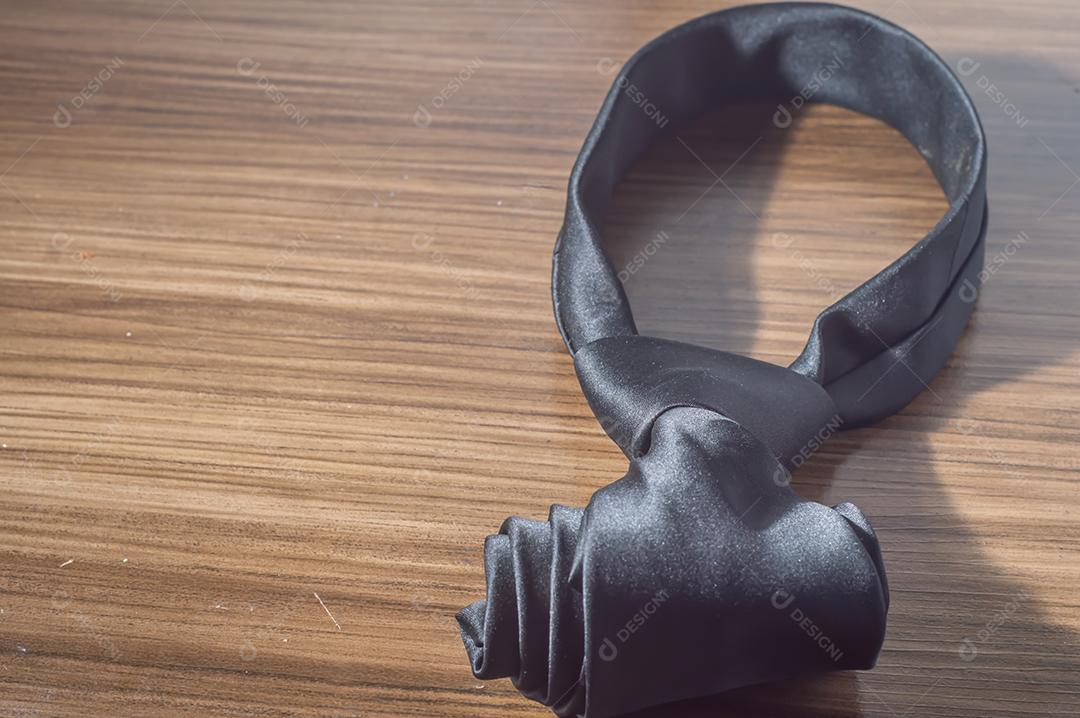 Gravata preta em uma mesa de madeira com espaço de cópia, conceito de dia dos pais.