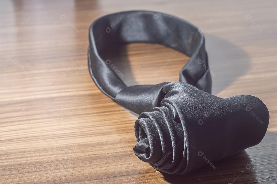 Gravata preta em uma mesa de madeira com espaço de cópia, conceito de dia dos pais.