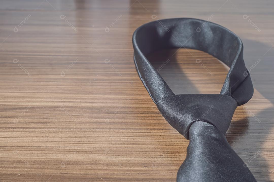 Gravata preta em uma mesa de madeira com espaço de cópia, conceito de dia dos pais.