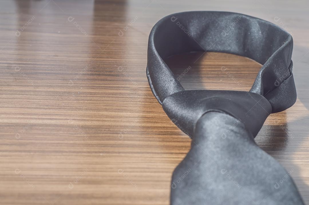 Gravata preta em uma mesa de madeira com espaço de cópia, conceito de dia dos pais.