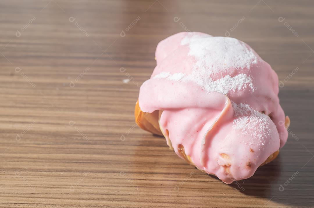 Croissant com cobertura de morango e recheio de doce de leite.