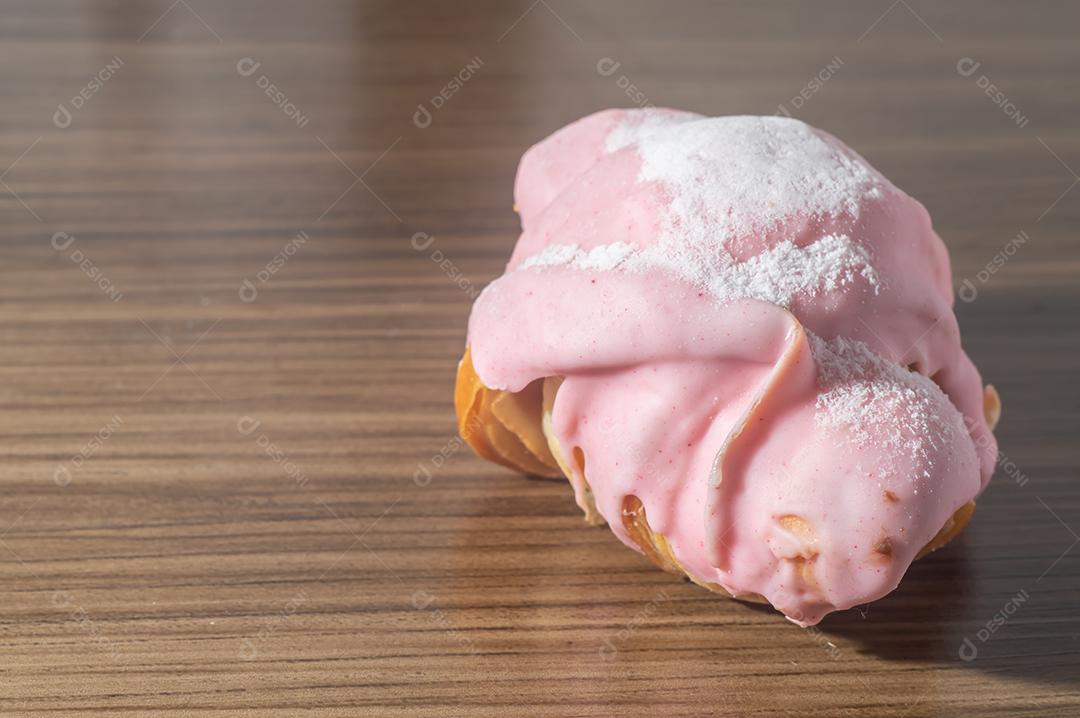 Croissant com cobertura de morango e recheio de doce de leite.