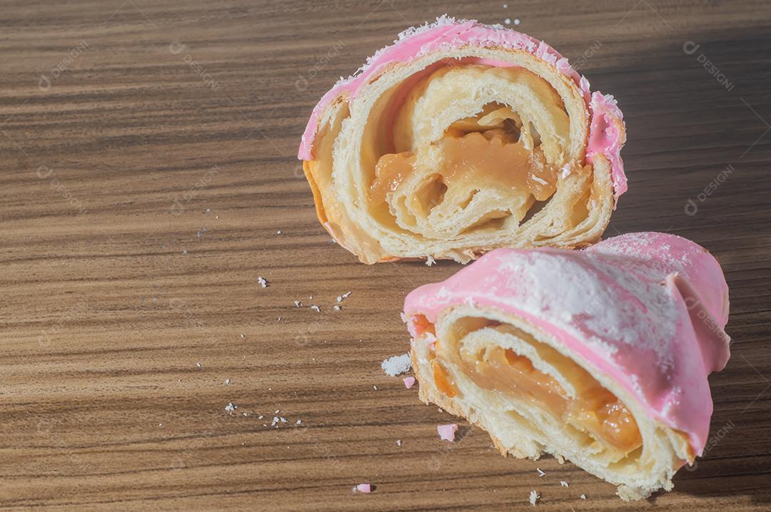 Croissant com cobertura de morango e recheio de doce de leite.