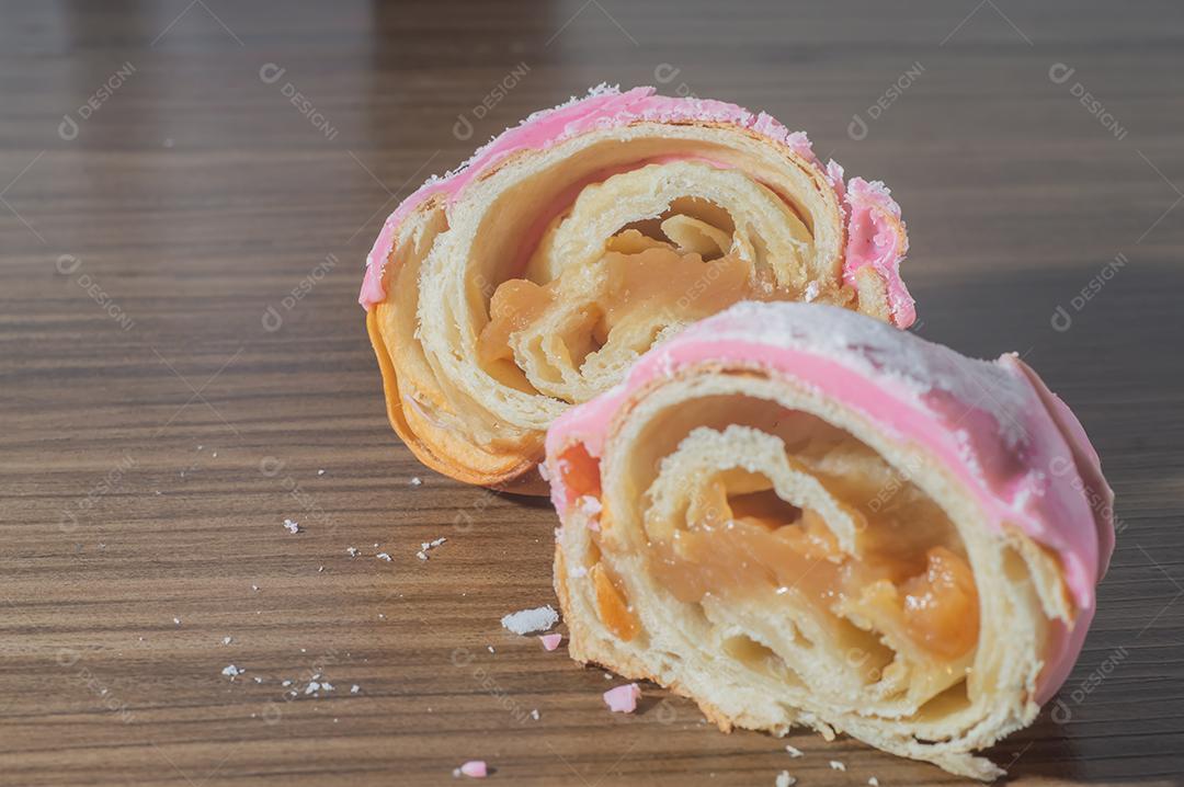 Croissant com cobertura de morango e recheio de doce de leite.