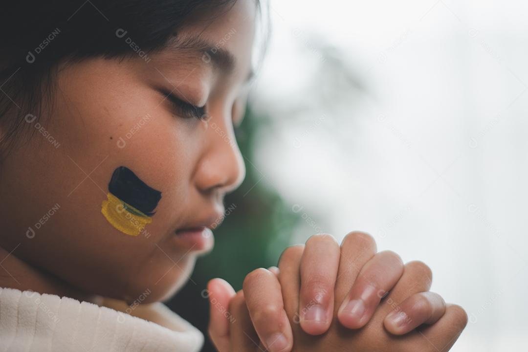 Uma criança com a bandeira da Ucrânia está chorando. Tristeza saudade esperança