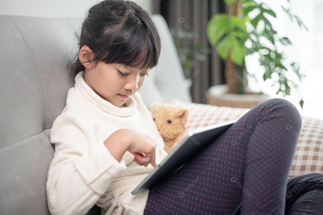 Menina usando tablet jogando na internet, Kid sitti