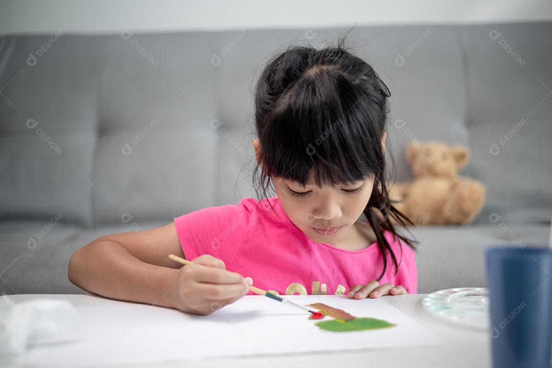 Menina pintando quadro na mesa em casa