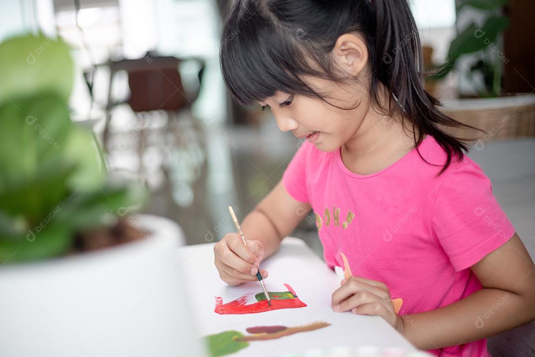 Menina pintando quadro na mesa em casa