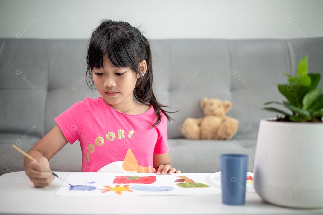 Menina pintando quadro na mesa em casa