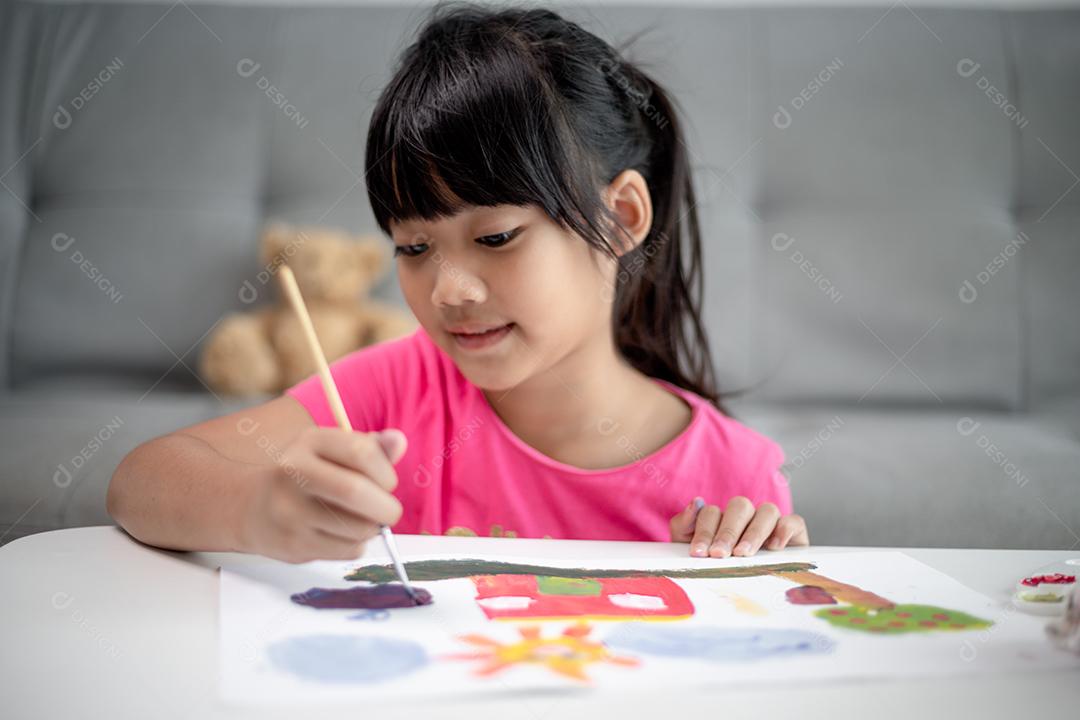 Menina pintando quadro na mesa em casa