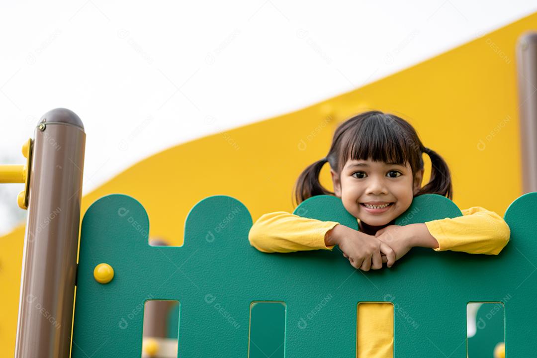 Menina asiática gosta de brincar em um parque infantil, Outdo