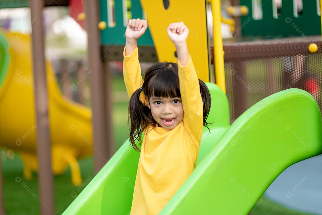 Menina asiática gosta de brincar em um parque infantil, Outdo