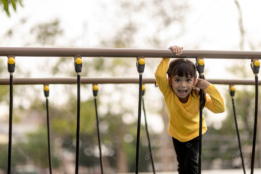 Menina asiática gosta de brincar em um parque infantil, Outdo