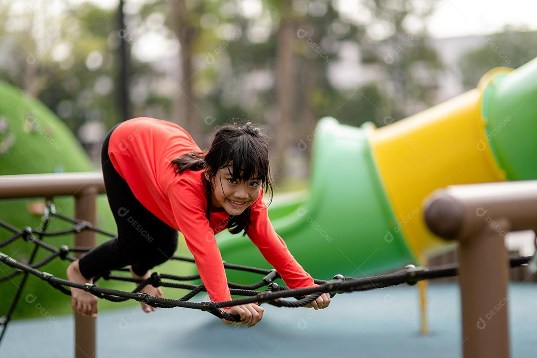 Menina asiática gosta de brincar em um parque infantil, Outdo