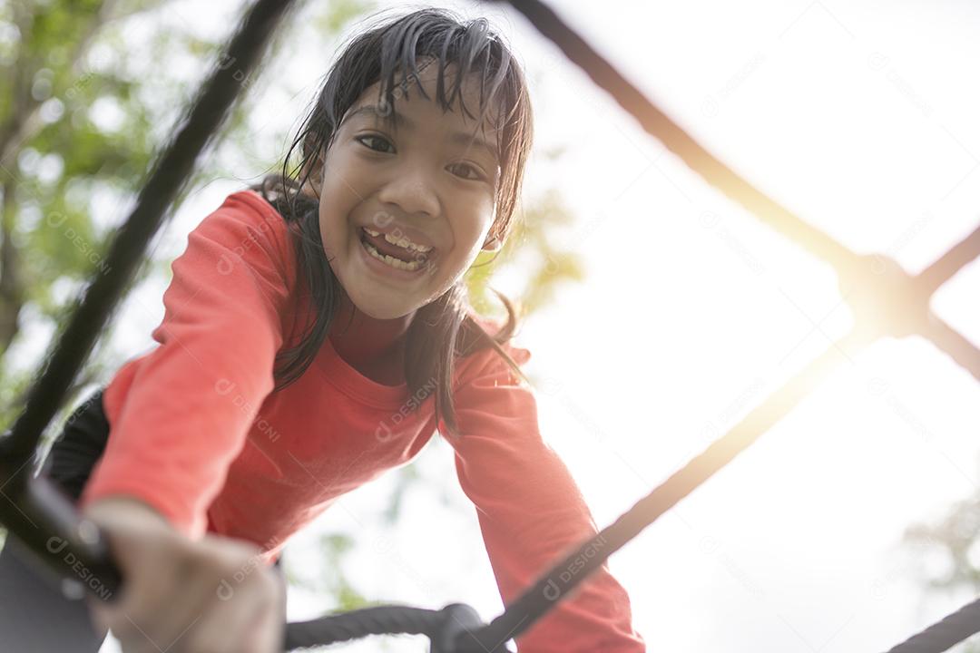 Menina asiática gosta de brincar em um parque infantil, Outdo