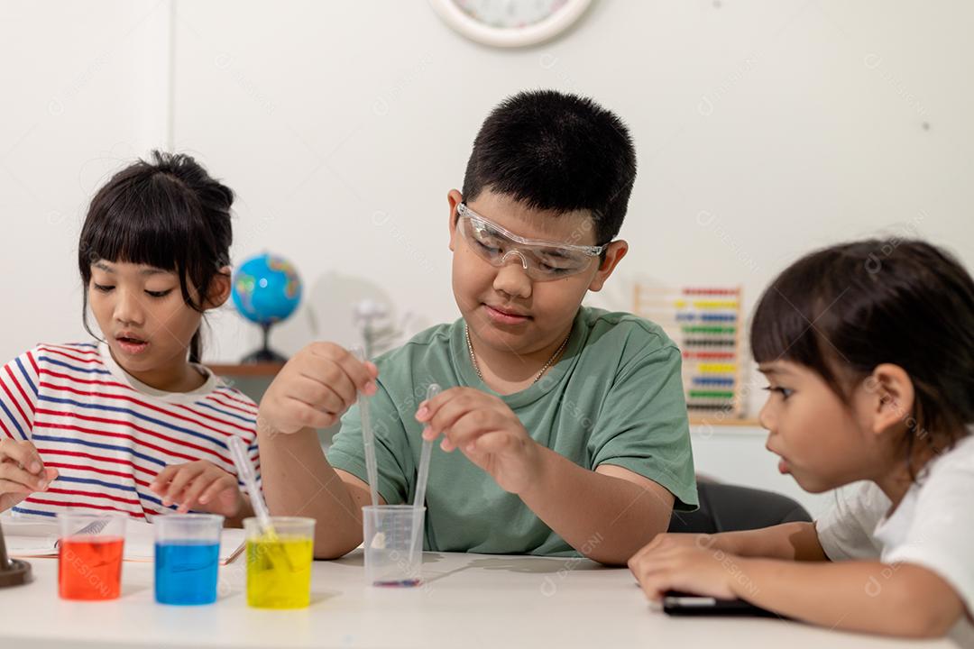 Crianças asiáticas fazem experimentos químicos em casa