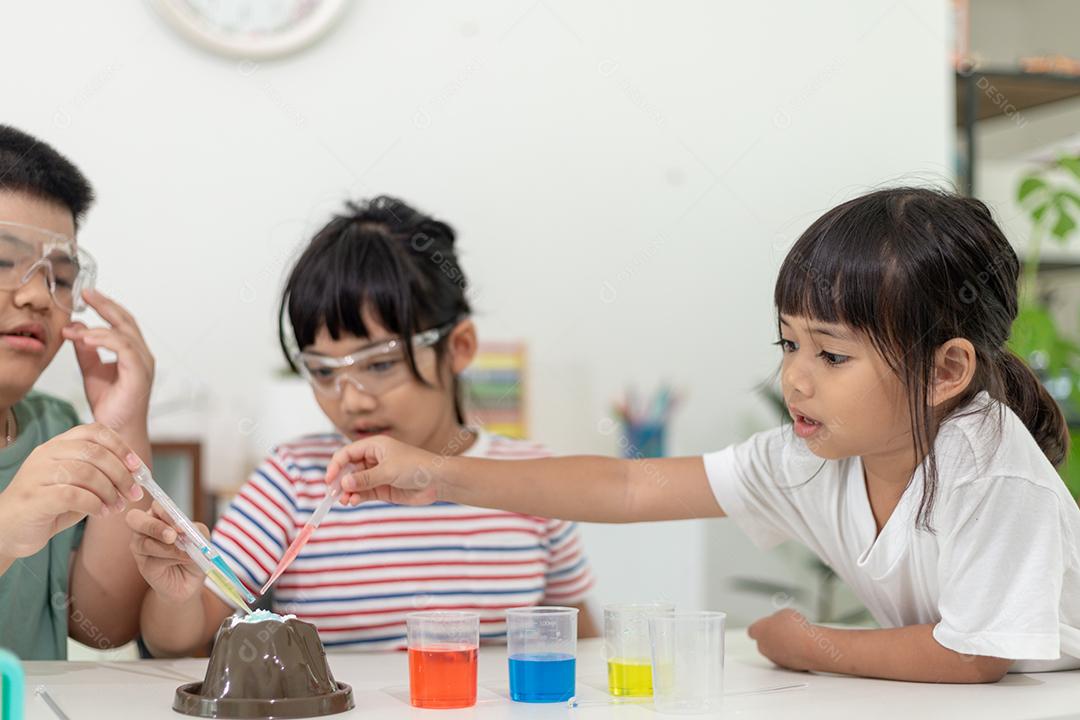 Crianças repetindo e observando um projeto de laboratório de ciências em casa - o vulcão de bicarbonato de sódio e vinagre