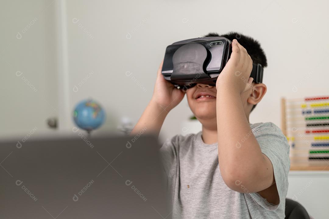 Menino asiático com óculos VR estudando ciências em casa, estudante curioso usa um fone de ouvido de realidade virtual para estudar ciência em casa estudo online estilo de vida futurista aprendizagem