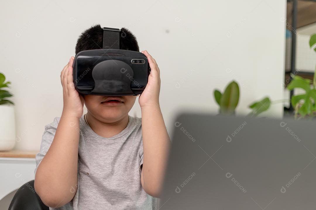 Menino asiático com óculos VR estudando ciências em casa, estudante curioso usa um fone de ouvido de realidade virtual para estudar ciência em casa estudo online estilo de vida futurista aprendizagem