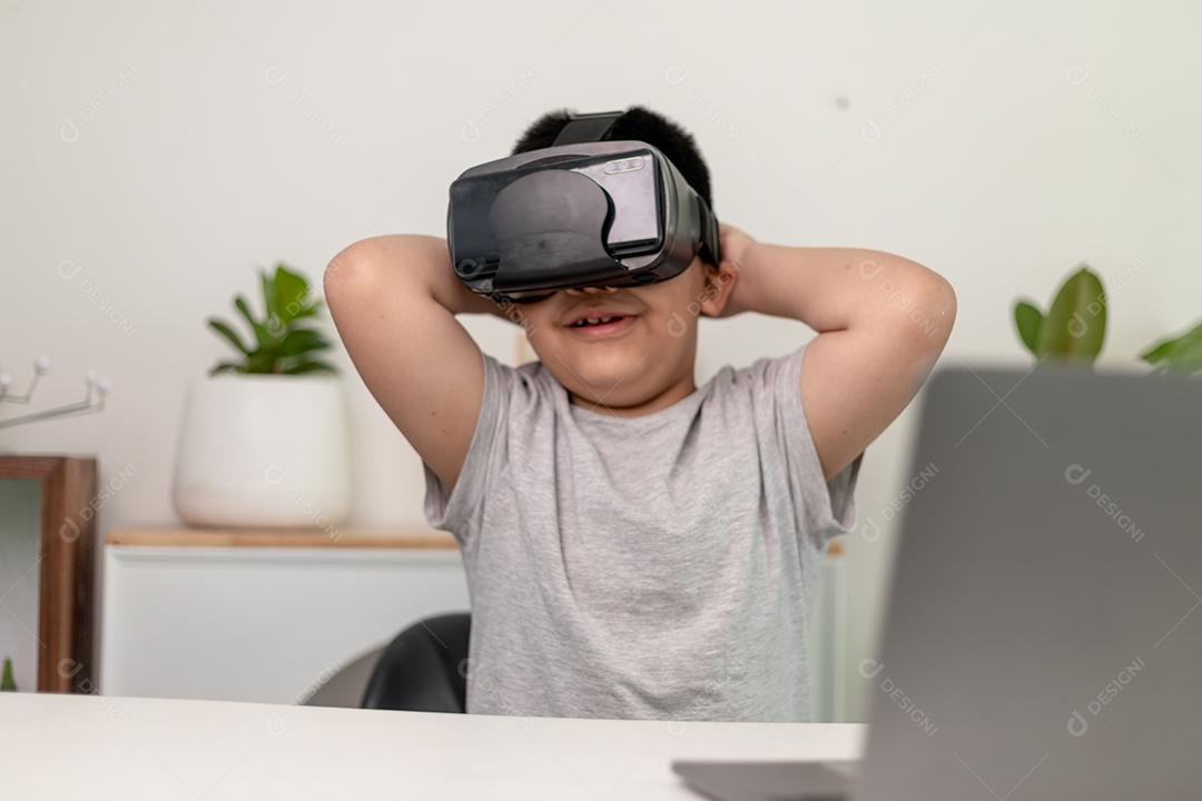 Menino asiático com óculos VR estudando ciências em casa, estudante curioso usa um fone de ouvido de realidade virtual para estudar ciência em casa estudo online estilo de vida futurista aprendizagem