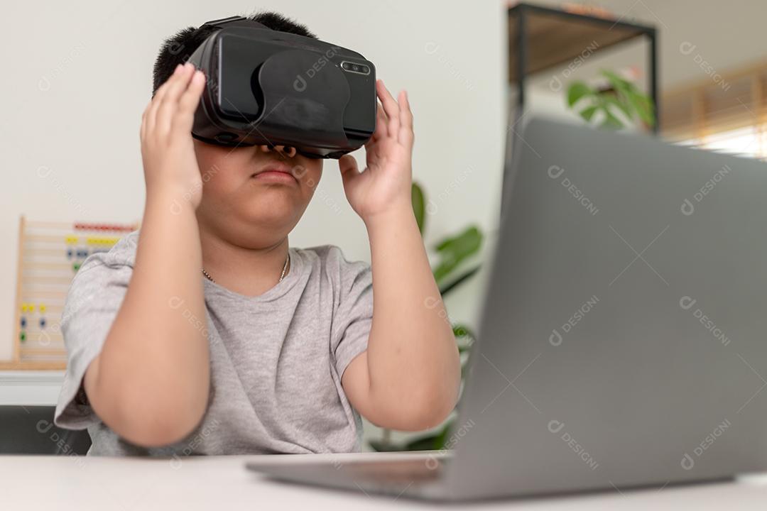 Menino asiático com óculos VR estudando ciências em casa, estudante curioso usa um fone de ouvido de realidade virtual para estudar ciência em casa estudo online estilo de vida futurista aprendizagem